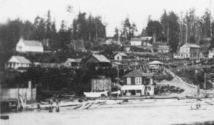 Camano City schoolhouse appears in the distance on the left on the top of the hill.